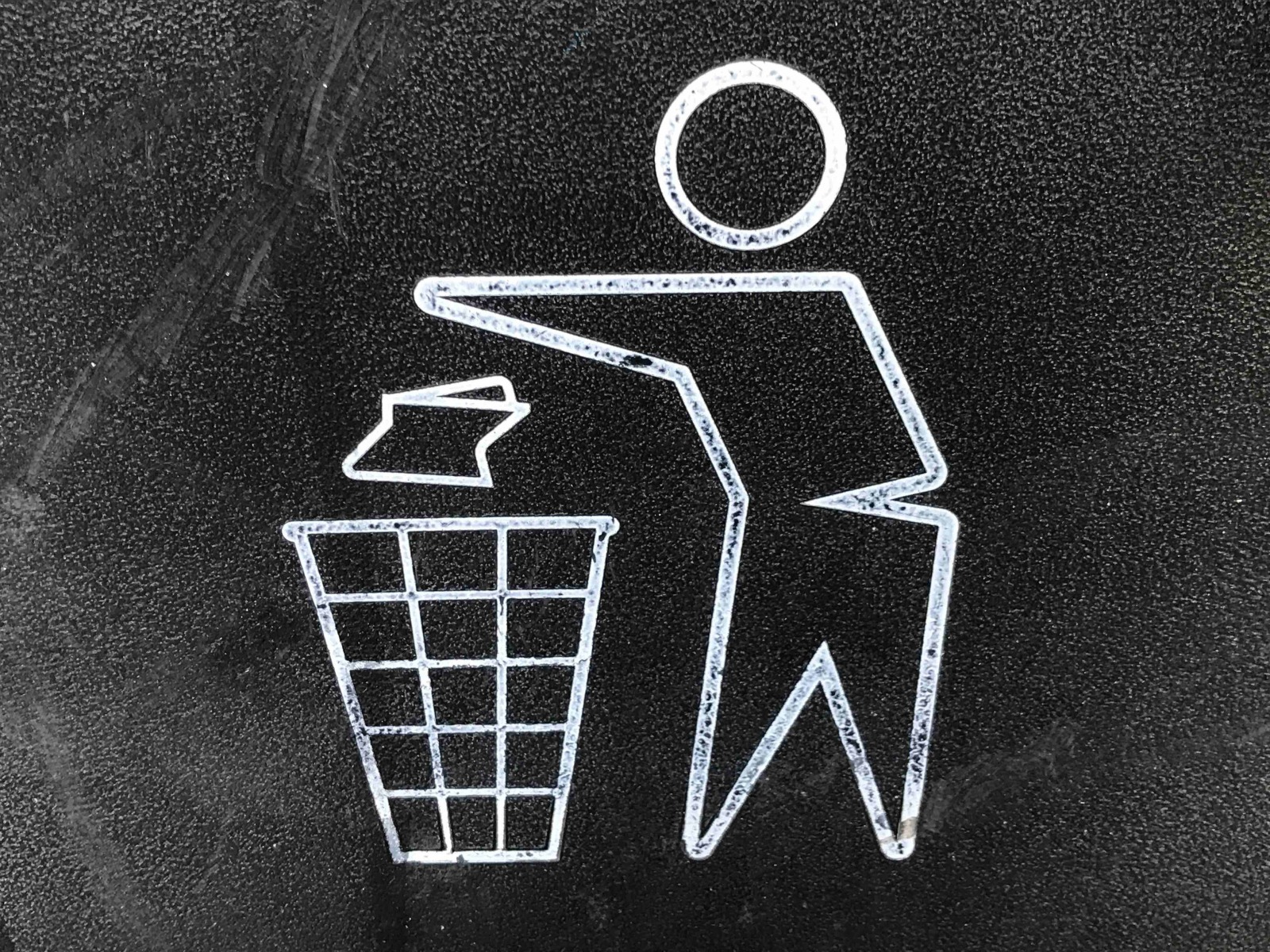 A silhouette cartoon figure throwing trash away.