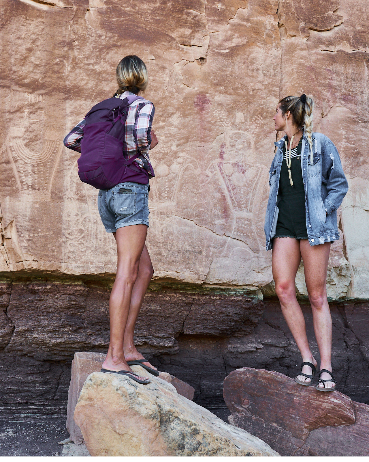 Two hikers looking at petroglyphs at Smithsonian Butte, Dinosaurland, Utah
