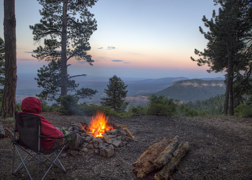 A campfire brings warmth to a camper overlooking Grand Canyon National Park from Kaibab National Forest, Arizona