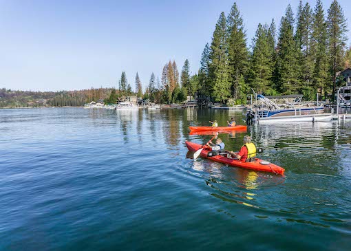 Family kayaking on Bass Lake in Madera County, California