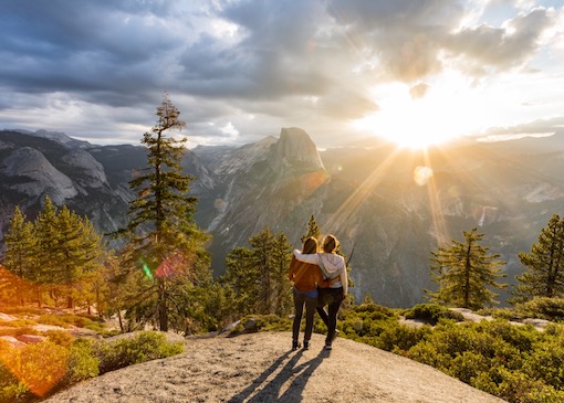 Two people watching sunrise at Glacier Point in Yosemite National Park