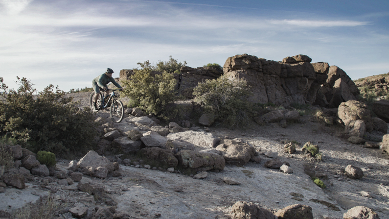 Man mountain biking through desert landscape