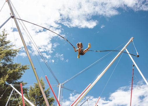 Person on Jackson Hole bungee trampoline with sky in background