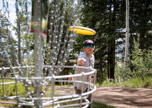 Person throwing frisbee in disc golf course in Jackson Hole, Wyoming