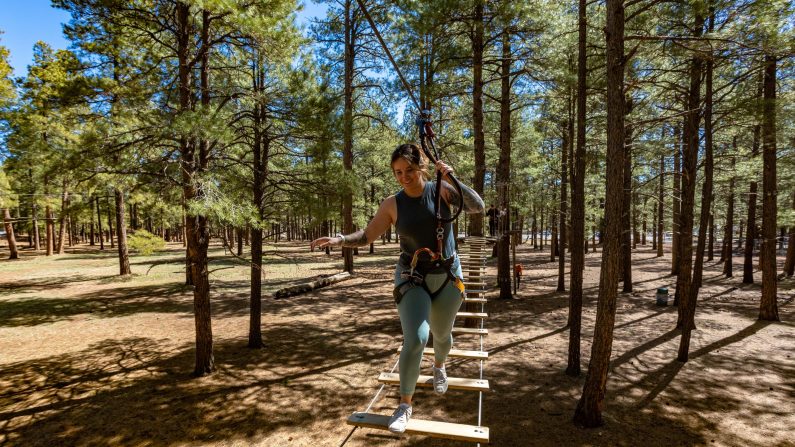 Woman on bridge on high ropes course at Flagstaff Extreme